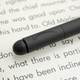 A close-up of the Kindle Scribe's Premium Pen stylus' eraser button on the end, sitting atop the Scribe's screen.